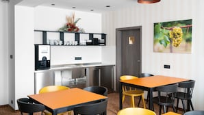 Habitación de hotel moderna con comedor, cocina y un amplio ventanal con vistas al exterior.