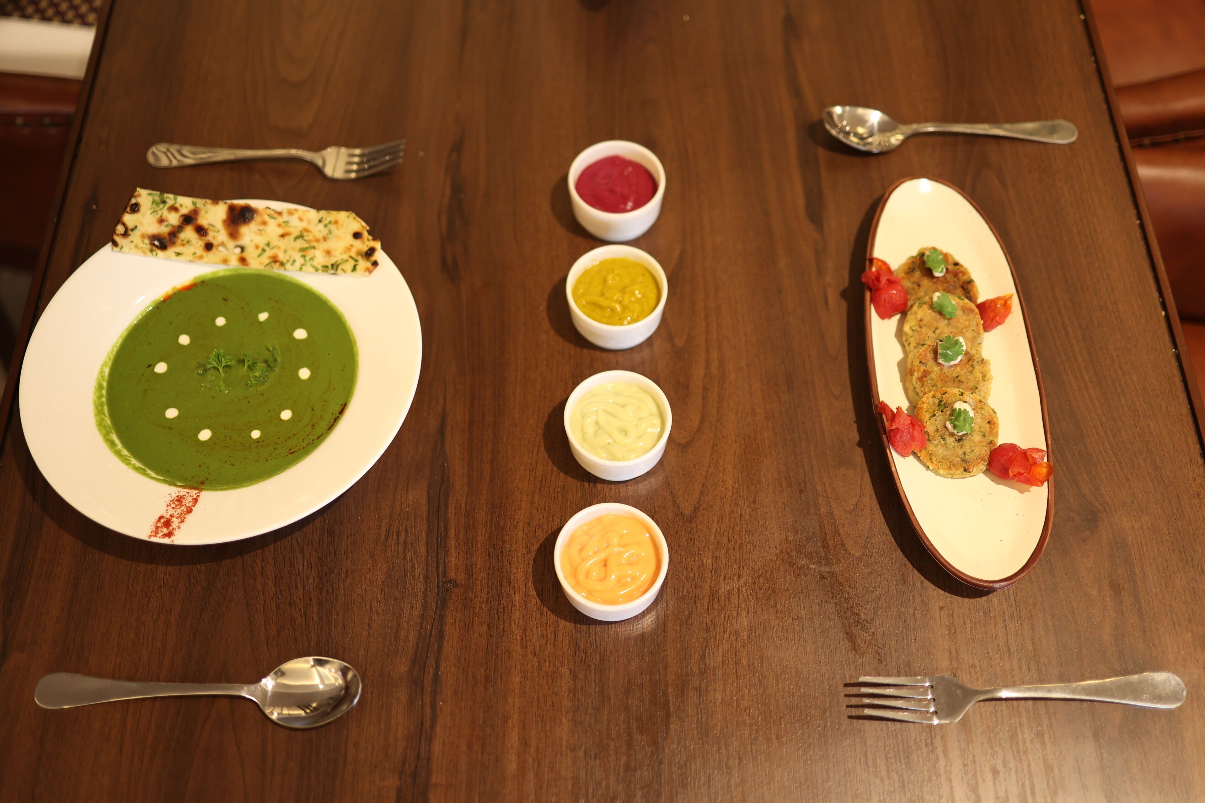 A wooden table with a variety of dishes and condiments.