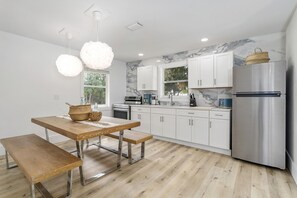 Prepare meals in the kitchen with a sleek refrigerator and dining table.