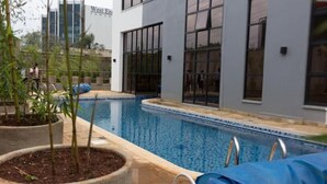 A modern building with a swimming pool, large windows, and a sign that reads "West End Tower." - Stay.Plus Nova Apartment Westlands (Nairobi)