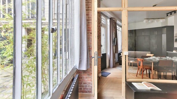 A modern apartment with large windows, a kitchen, and a dining area. - NEW Design Flat in the Heart of Paris-An Ecoloflat (Paris)