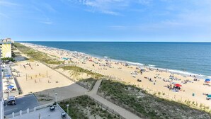 Una spiaggia con un campo da pallavolo, una zona sabbiosa e vista sull'oceano.