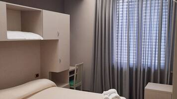 Une chambre d’hôtel avec un grand lit, un bureau, une chaise et un téléviseur.