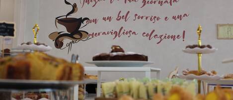 Ein Buffet mit verschiedenen Speisen und einer Wanddekoration mit einer Kaffeetasse und Text.