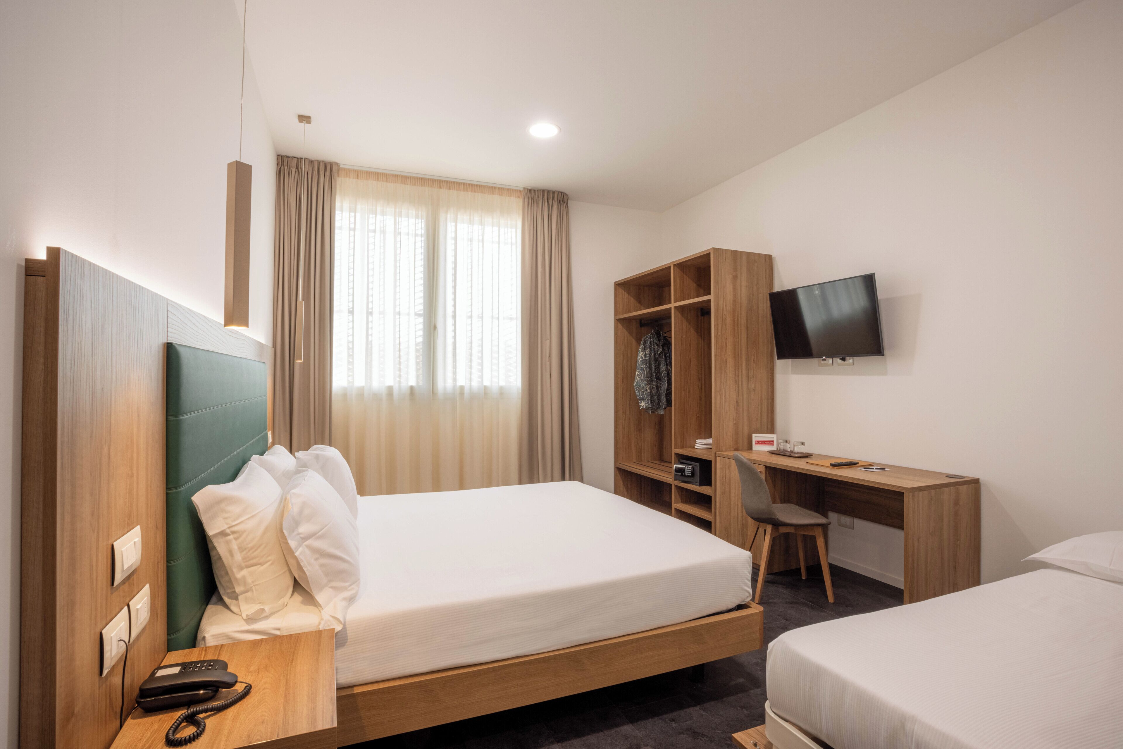 أسرّة بإسفنج يتكيف مع شكل الجسم وميني بار وخزنة داخل الغرفة ومكتب