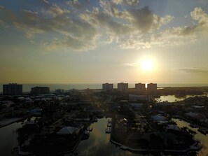 A coastal cityscape at sunset with buildings, a marina, and a body of water. - Beachfront 2BR/2BA condo on Marco Island with pool, WiFi, and beach access. (Marco Island)