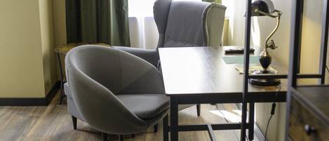 A room with a desk, a chair, a lamp, and a bookshelf.