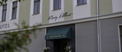 A hotel building with a sign reading "König Albert" and "Stadthotel" indicating a city hotel.