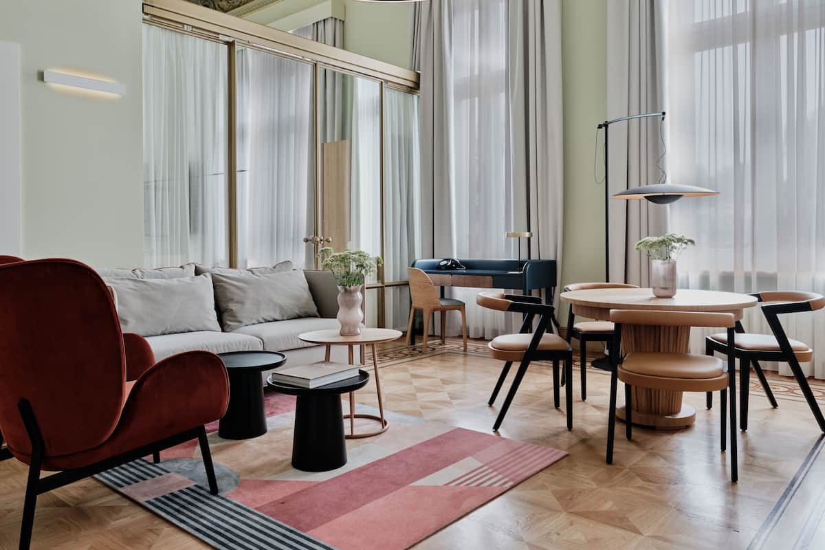 A modern living room with a sofa, chairs, a coffee table, and a dining area with a table and chairs.