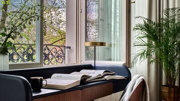 A study area with a desk, books, a mug, and a potted plant.