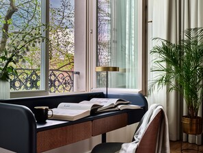 A study area with a desk, books, a mug, and a potted plant. - Hotel Altus Palace - Destigo Hotels (Wroclaw)