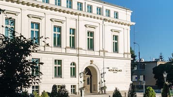 A large, white building with a classic architectural style, featuring multiple windows and an arched entrance.