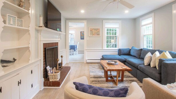 A living room with a fireplace, a sofa, a coffee table, and a ceiling fan. - Minutes to Nantucket Sound Beaches! (South Yarmouth)