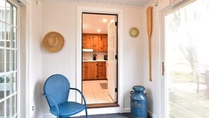 A room with a blue chair, a wooden door, a blue container, and a hat on the wall. - Minutes to Nantucket Sound Beaches! (South Yarmouth)