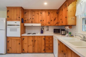 A kitchen with wooden cabinets, a white refrigerator, a microwave, and a sink. - Minutes to Nantucket Sound Beaches! (South Yarmouth)