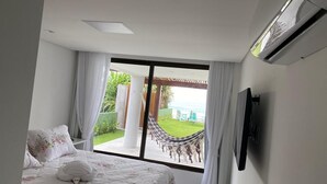 Un dormitorio con un ventanal grande, una hamaca y un equipo de aire acondicionado.
