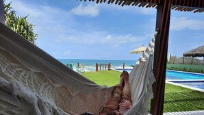 Una hamaca con vista a una piscina y al océano.