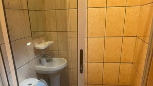 Een badkamer met toilet, bidet en douchecabine.