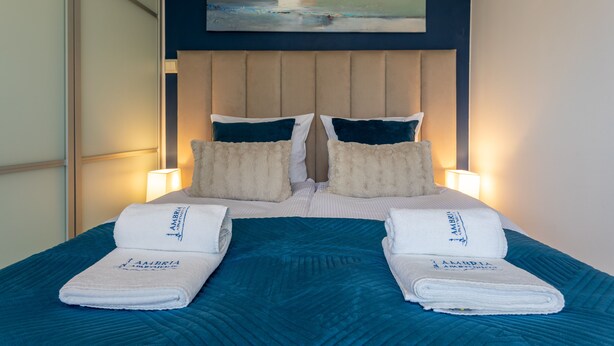 A neatly made bed with a blue quilt, two pillows, and two folded towels on the side. - Vacation apartment by the sea, vacation on the island of Usedom, Apartment WIND ROSE 33 (Świnoujście)