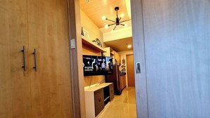 Ein modernes Hotelzimmer mit Holzschränken, einem Flachbildfernseher und einem Deckenventilator.