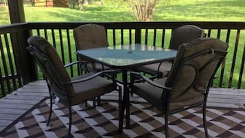 Relax in a serene outdoor seating area with a checkered floor, glass table, and comfortable chairs.