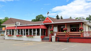 A restaurant with a red awning, outdoor seating, and a 'RESTO' sign.