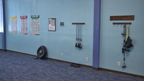 A fitness room with exercise equipment, posters on the wall, and a fan on the floor. - 1205  Pool, Hot tub, sauna - The Relaxing Shed (Beech Mountain)