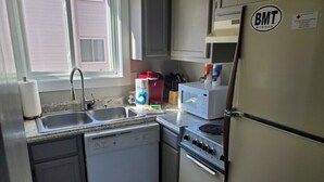 A compact kitchen with a dishwasher, stove, microwave, and refrigerator. - 1205  Pool, Hot tub, sauna - The Relaxing Shed (Beech Mountain)