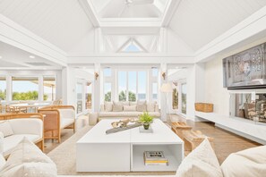 A spacious living room with a white coffee table, a sofa, and a television.