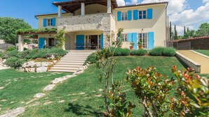 A two-story house with a stone facade, blue shutters, and a front porch. - Villa Vista Azzurra with pool, summer kitchen and well-tended garden (Sveti Lovreč)
