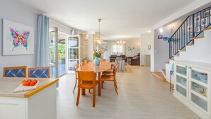 A spacious kitchen with a dining area, a staircase, and a living room with a sofa and a coffee table. - Villa Vista Azzurra with pool, summer kitchen and well-tended garden (Sveti Lovreč)