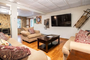 A living room with a stone fireplace, a television, and a dartboard. - Hike the SNP-Massanutten Resort FREE Resort Rec Access & Dog Friendly! (McGaheysville)