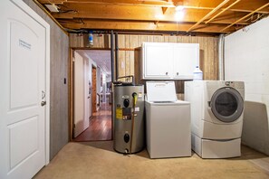 A laundry room with a washer, dryer, and water heater.