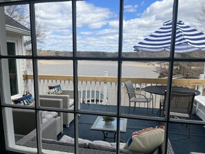 A deck with wicker furniture, a table, and a view of a lake. - *Stunning Waterfront Views! PVT Deep Water Dock (Clarksville)