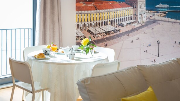A dining area with a table set for breakfast, overlooking a historic square with a waterfront view. - Vita Portucale | Downtown Premium with Garage (Lisboa)