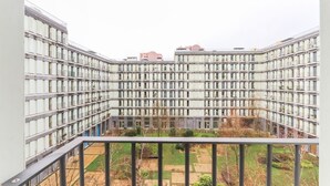 Un edificio residencial alto con varios balcones y un patio interior.