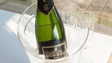 A bottle of Louis Blanc Brut champagne in a glass container on a table.