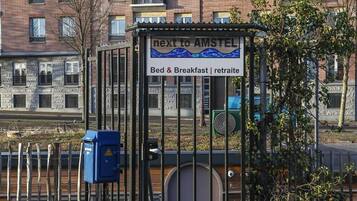 Una entrada porticada a un edificio con un letrero que indica que está cerca de Ámsterdam.