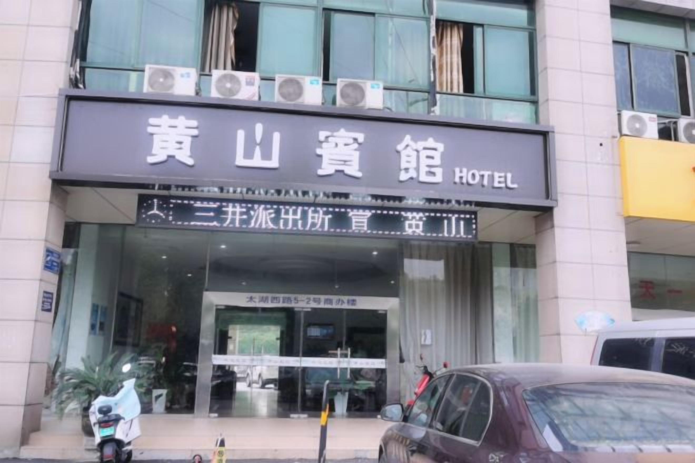 A hotel entrance with a sign indicating '黄山宾馆 HOTEL' and '三峰派出所'.