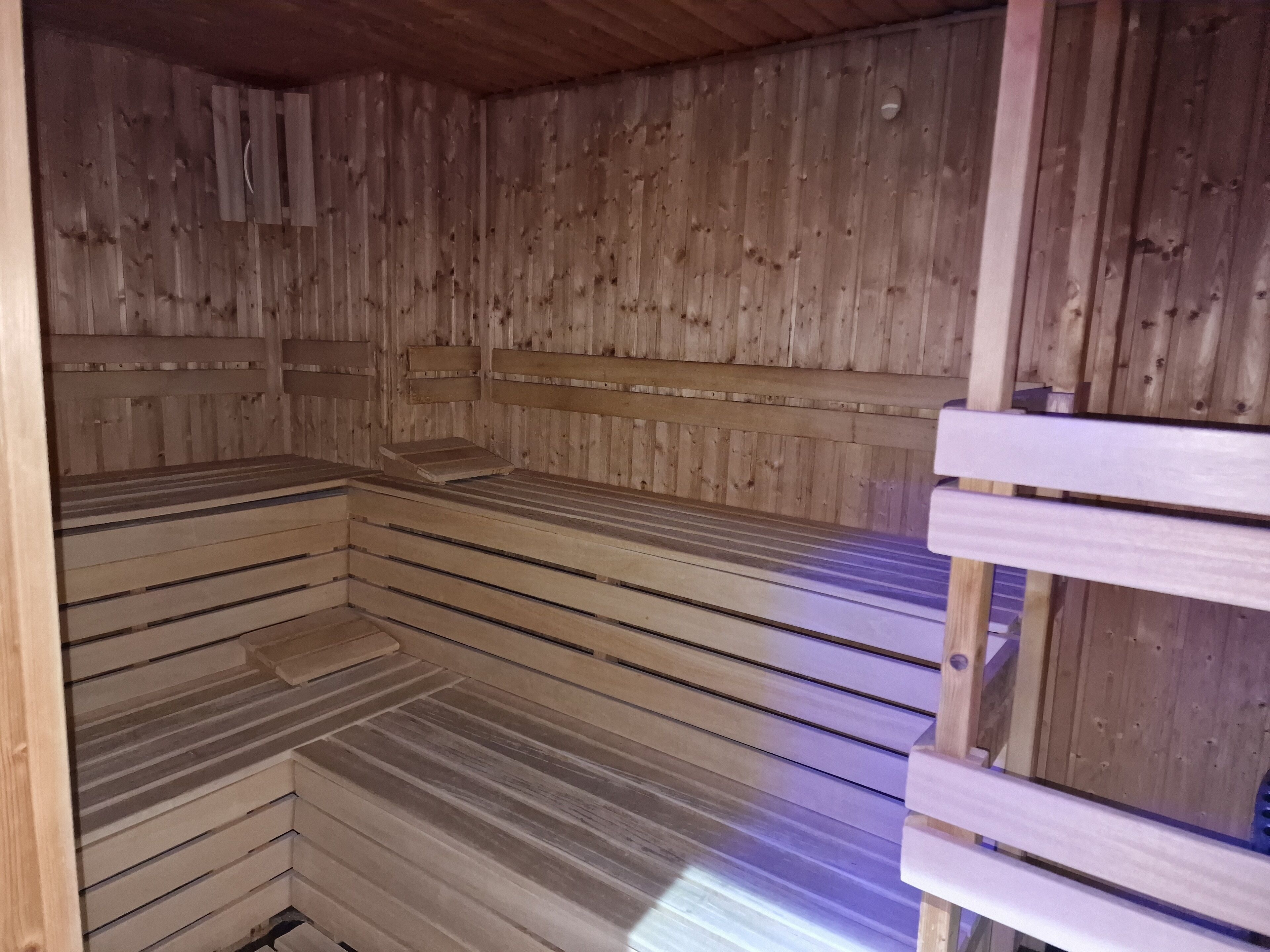 A wooden sauna with benches and a bench seat.
