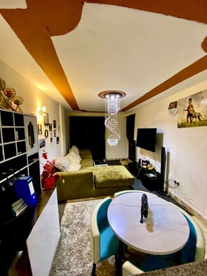 Una sala de estar acogedora con un sofá, una mesa de centro y un televisor.