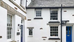 A white building with a blue door, stone steps, and a gravel driveway. - The Cornish Peak: Cornwall by STAE-Homes (Cornwall)