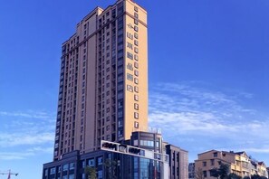 Un immeuble de grande hauteur, doté de nombreux étages, de grandes fenêtres et surplombant un ciel dégagé.