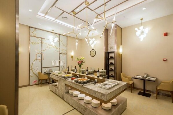 A modern interior with a central island counter, seating area, and decorative lighting. - CYTS Shanshui Fashion Hotel (Chibi Railway Station) (Chibi)