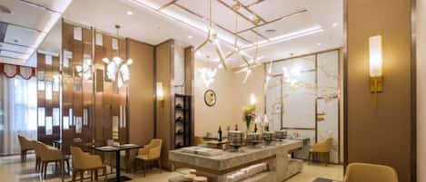 Un moderno vestíbulo de hotel con barra central, zonas de estar y una iluminación decorativa.
