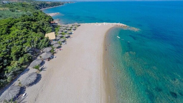 An aerial view of a beach with clear blue waters, a sandy shore, and some greenery. - Armonia by the Sea - Majestic Seaside Retreat (Petalidi)