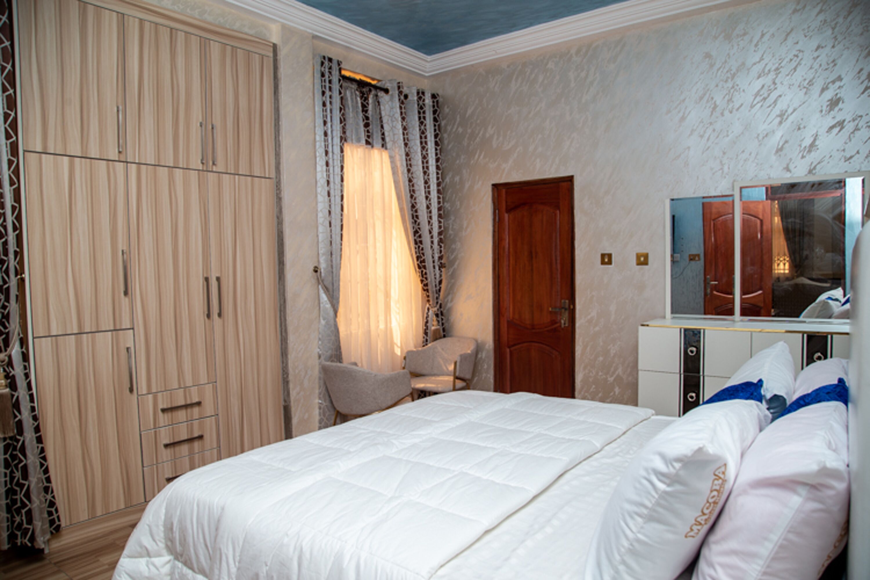 A bedroom with a bed, wardrobe, and a mirror.
