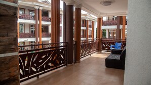 Un vaste espace intérieur doté d’un balcon, de colonnes et d’un coin salon.