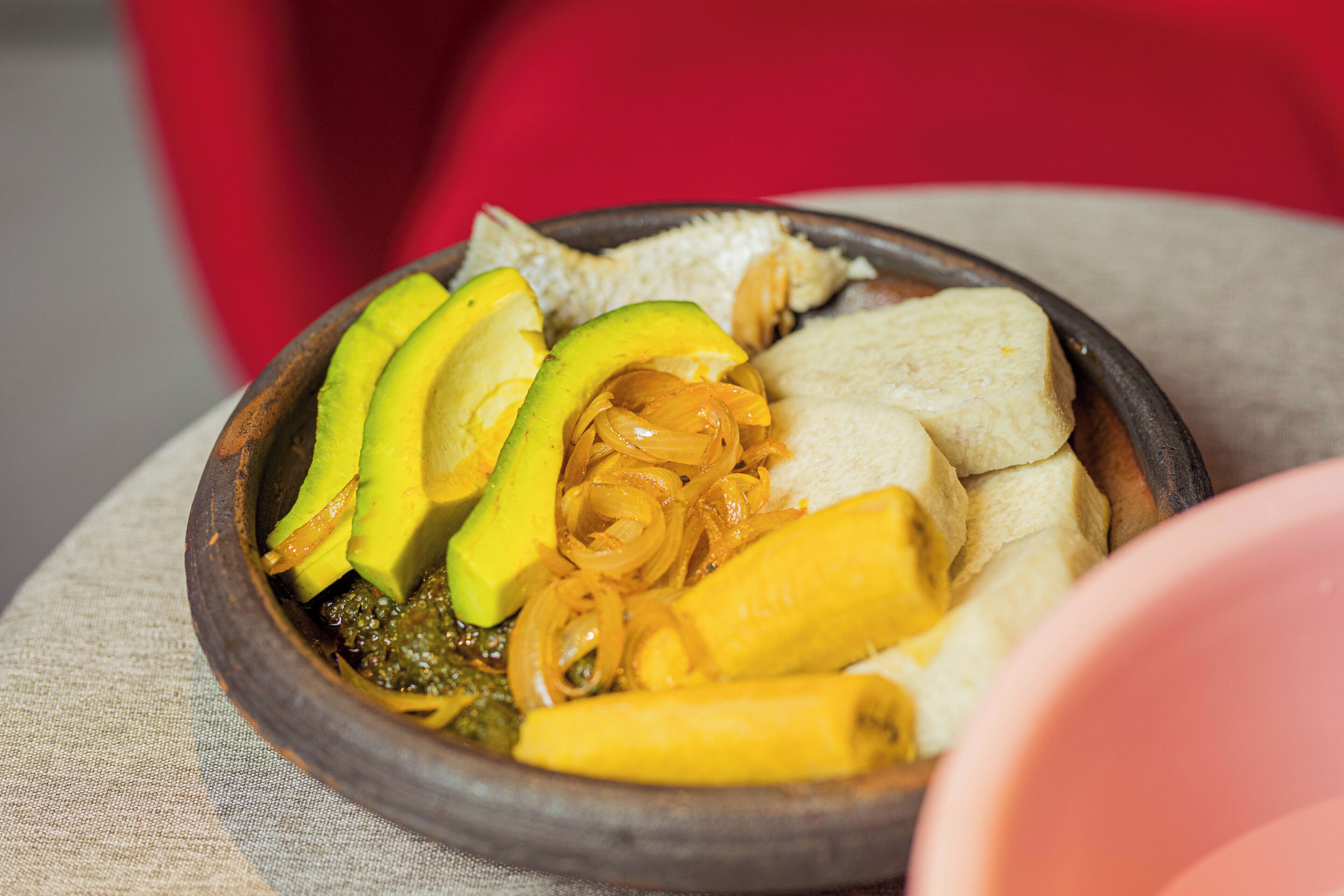 A bowl of food with avocado, onions, and bread.
