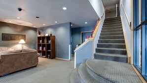 Een modern interieur met een trap, een bank en een boekenkast.